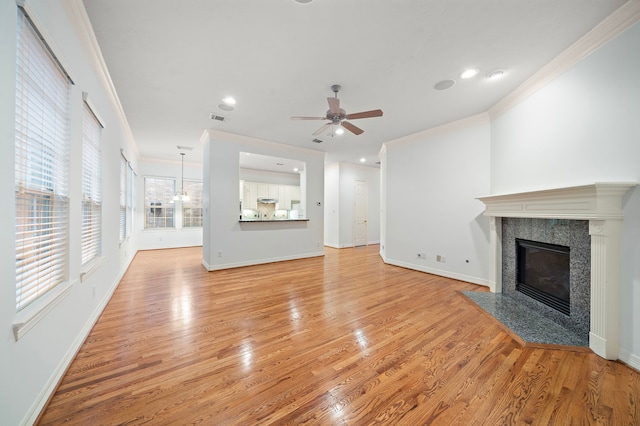 unfurnished living room with crown molding, light hardwood / wood-style floors, and a fireplace