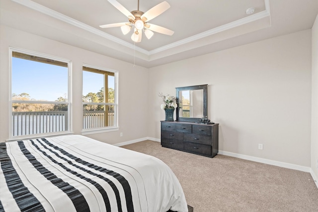 bedroom featuring a raised ceiling, ceiling fan, light colored carpet, and ornamental molding