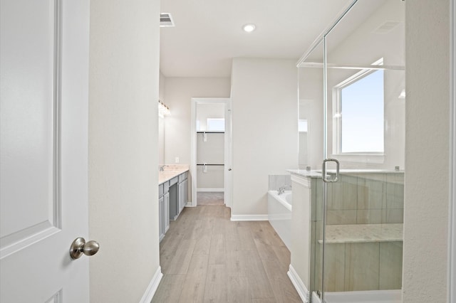 bathroom featuring hardwood / wood-style floors, vanity, and shower with separate bathtub