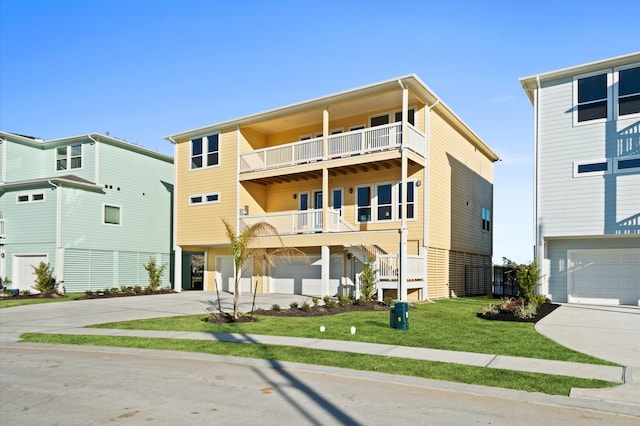 view of front of home featuring a balcony, a front yard, and a garage