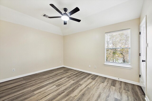 empty room featuring hardwood / wood-style flooring, vaulted ceiling, and ceiling fan