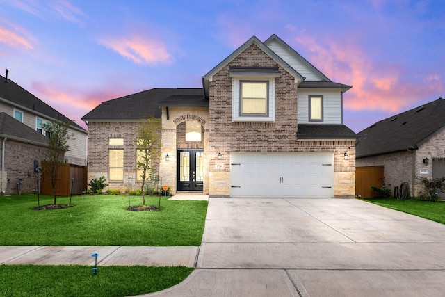 view of front facade with a yard, french doors, and a garage