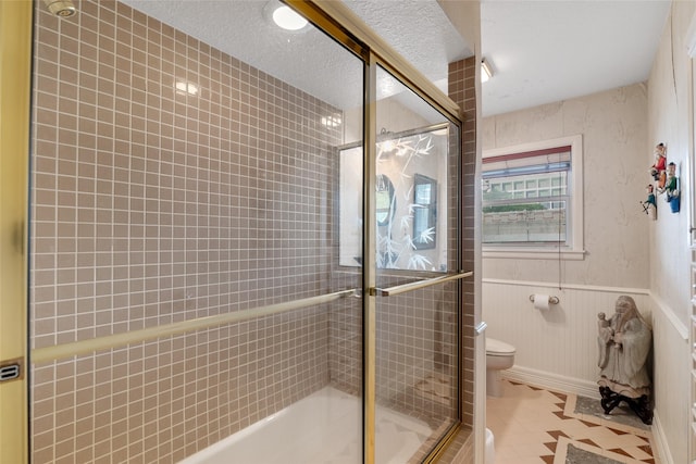 bathroom with tile patterned floors, toilet, and enclosed tub / shower combo