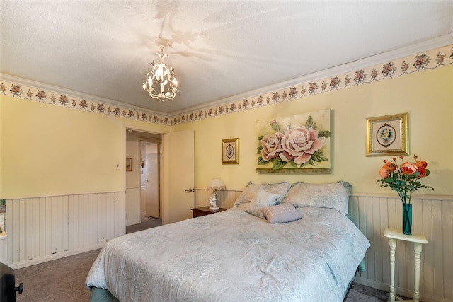 bedroom with carpet flooring, crown molding, a textured ceiling, and an inviting chandelier