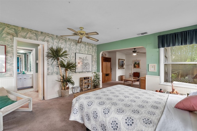 carpeted bedroom featuring ensuite bathroom and ceiling fan