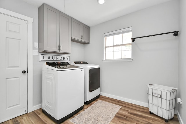 laundry room featuring cabinets, washer and clothes dryer, and hardwood / wood-style floors