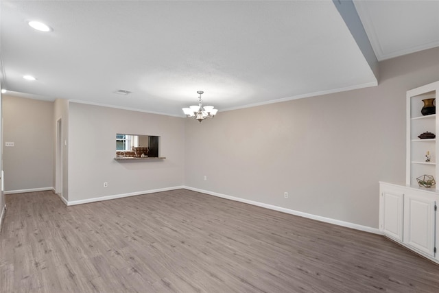 unfurnished living room with light hardwood / wood-style flooring, ornamental molding, and a notable chandelier