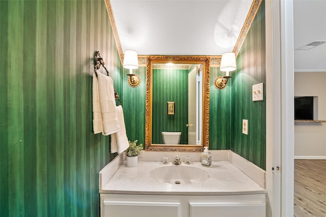 bathroom with vanity, toilet, and ornamental molding