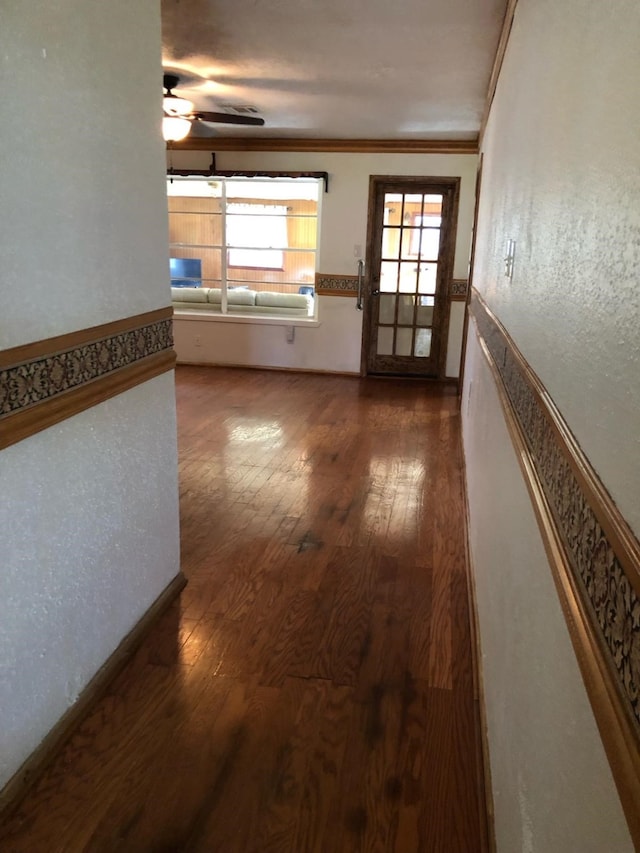 unfurnished living room with wood-type flooring, ceiling fan, and crown molding