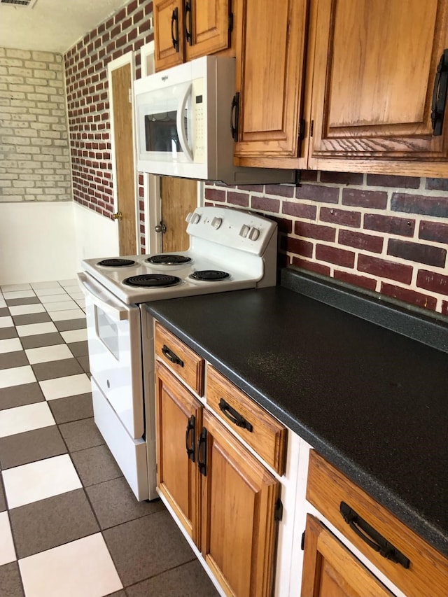 kitchen with white appliances and brick wall