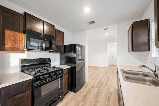 14519 Broadbury Pond Rd, Rosharon, TX 77583 - kitchen with black appliances, a sink, light wood-type flooring, light countertops, and dark brown cabinetry