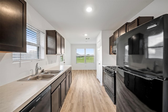 14519 Broadbury Pond Rd, Rosharon, TX 77583 - kitchen with black appliances, a sink, light wood-style floors, dark brown cabinets, and light countertops