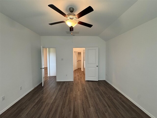 unfurnished bedroom with ceiling fan, dark wood-type flooring, vaulted ceiling, a walk in closet, and a closet