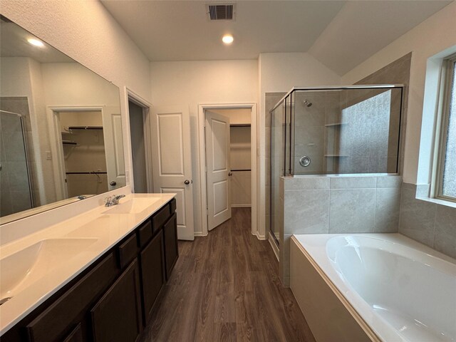 bathroom with vanity, wood-type flooring, and plus walk in shower