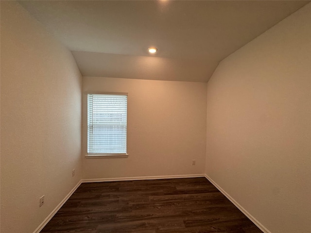 unfurnished room with dark wood-type flooring and lofted ceiling