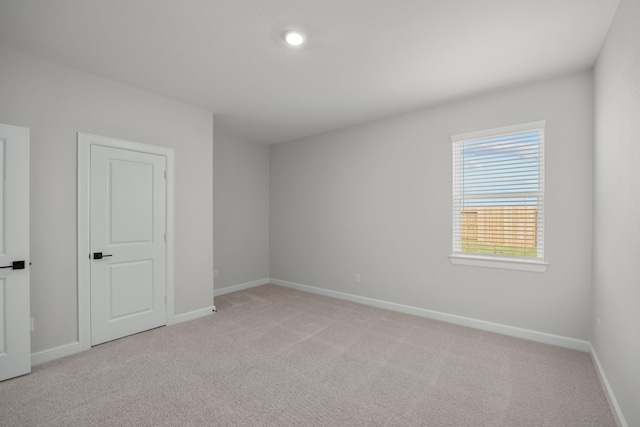 spare room featuring light colored carpet