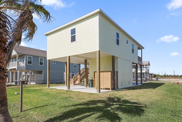 rear view of house featuring a lawn and a patio area