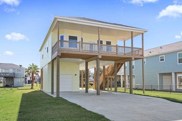 22805 Miramar Dr, Galveston, TX 77554 - back of property featuring an attached garage, a carport, concrete driveway, stairs, and a deck