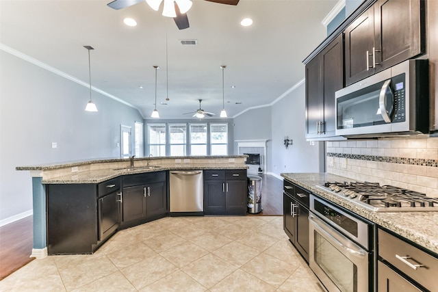 kitchen featuring ceiling fan, stainless steel appliances, ornamental molding, pendant lighting, and light stone counters