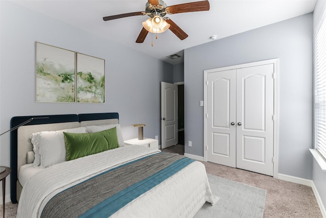 carpeted bedroom featuring ceiling fan and a closet