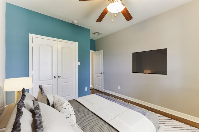 bedroom with ceiling fan, wood-type flooring, and a closet