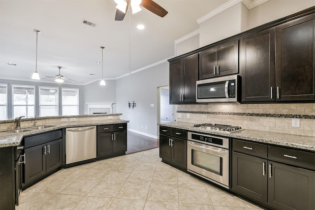 kitchen with pendant lighting, sink, dark brown cabinetry, light stone countertops, and stainless steel appliances