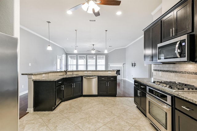 kitchen featuring pendant lighting, stainless steel appliances, ceiling fan, sink, and light stone counters