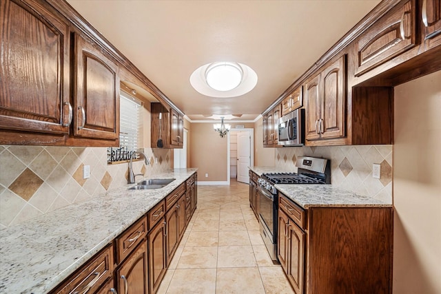 kitchen with light tile patterned flooring, appliances with stainless steel finishes, light stone countertops, and sink