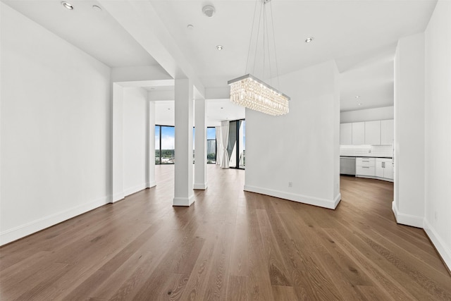 interior space with hardwood / wood-style floors, a wall of windows, and an inviting chandelier