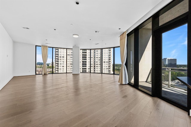 spare room featuring light hardwood / wood-style floors and expansive windows