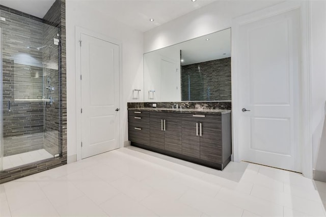 bathroom with tile patterned floors, a shower with door, and vanity