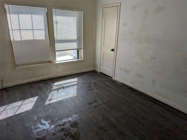 empty room featuring baseboards and wood finished floors