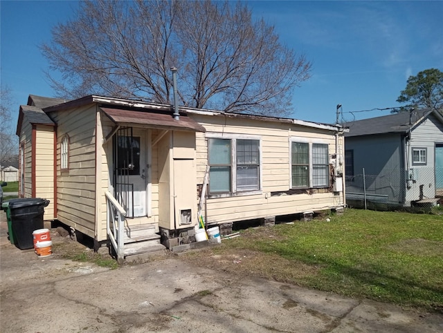 view of front of home featuring entry steps and a front lawn