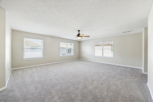 unfurnished room featuring ceiling fan, light colored carpet, and a textured ceiling