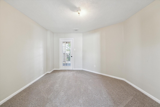 unfurnished room with carpet flooring and a textured ceiling