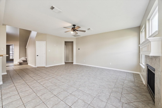 unfurnished living room with ceiling fan, light tile patterned flooring, and a premium fireplace