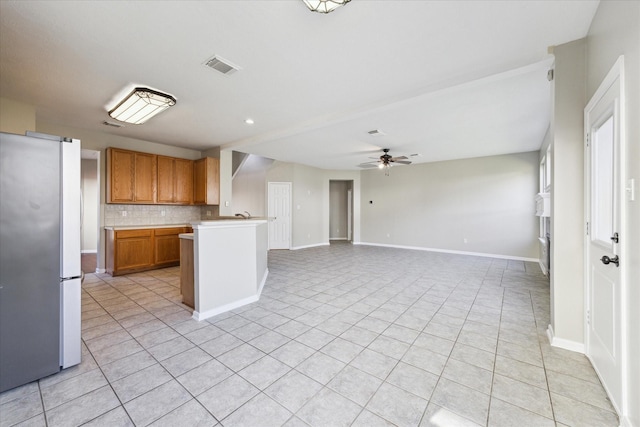 kitchen featuring kitchen peninsula, stainless steel fridge, backsplash, ceiling fan, and light tile patterned floors