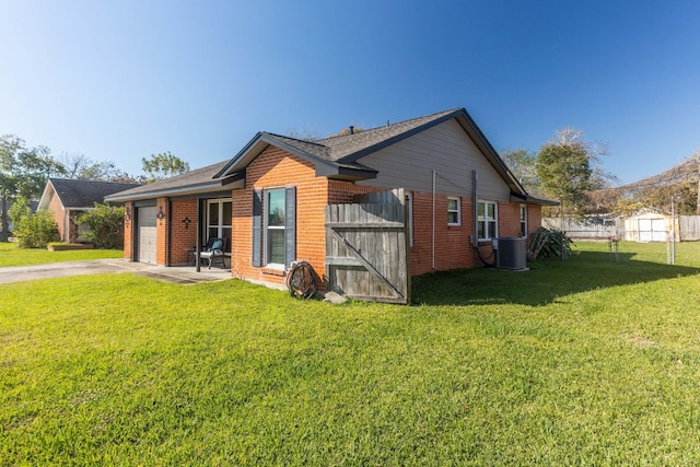 view of home's exterior with cooling unit, a garage, and a yard