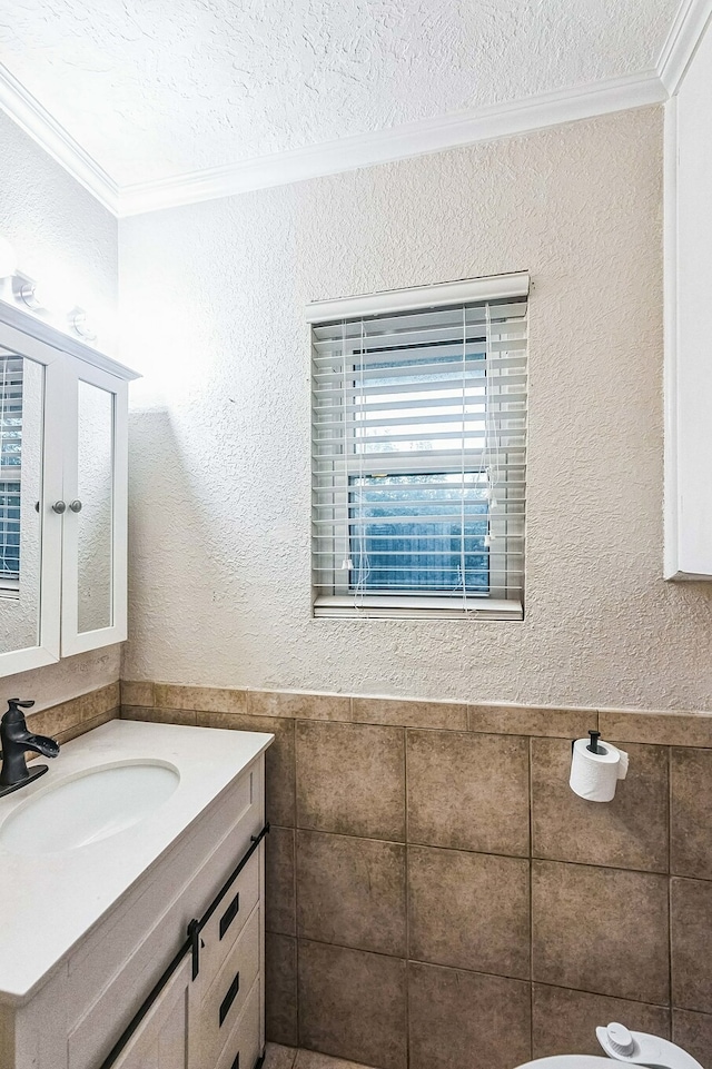 bathroom with vanity, ornamental molding, and a textured ceiling