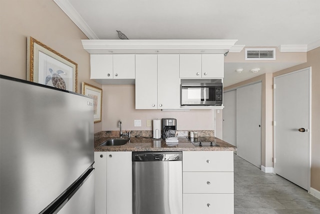 kitchen featuring white cabinetry, sink, dark stone countertops, crown molding, and appliances with stainless steel finishes