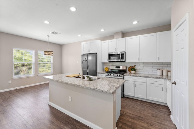 kitchen with white cabinets, a kitchen island with sink, and appliances with stainless steel finishes