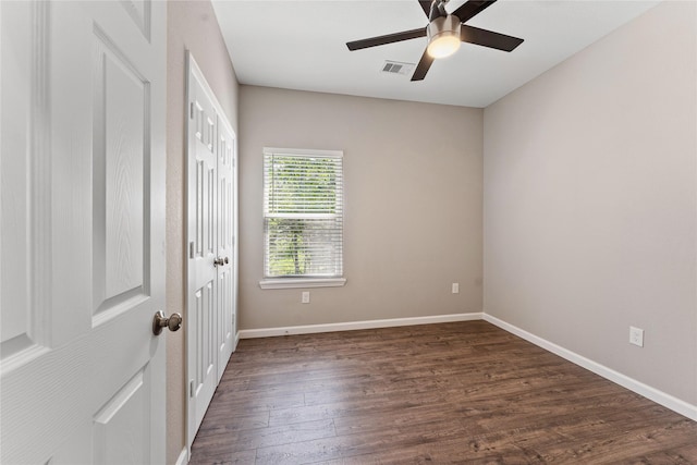 unfurnished room with dark hardwood / wood-style flooring and ceiling fan