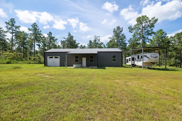 rear view of property with a carport, a garage, an outbuilding, and a lawn