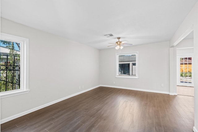 spare room with ceiling fan, dark hardwood / wood-style flooring, and a wealth of natural light