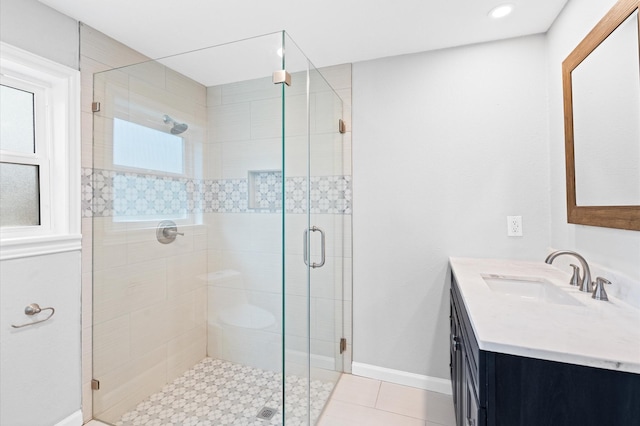 bathroom featuring walk in shower, vanity, tile patterned floors, and a wealth of natural light