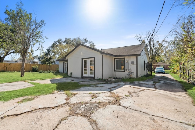 rear view of property featuring a lawn and french doors