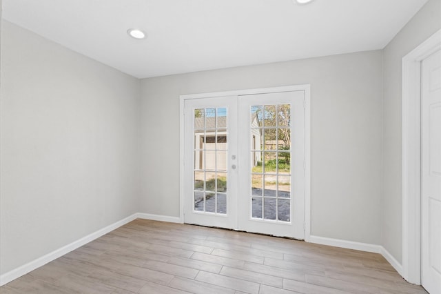 empty room featuring french doors and light hardwood / wood-style floors