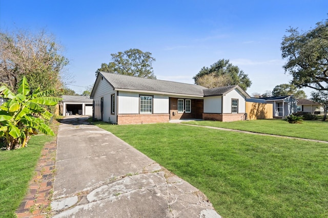 ranch-style house with a front yard, an outdoor structure, and a garage