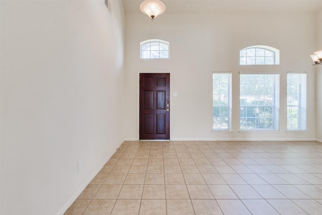 foyer featuring light tile patterned floors, a high ceiling, and a wealth of natural light