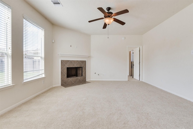 unfurnished living room featuring ceiling fan, a fireplace, and light colored carpet